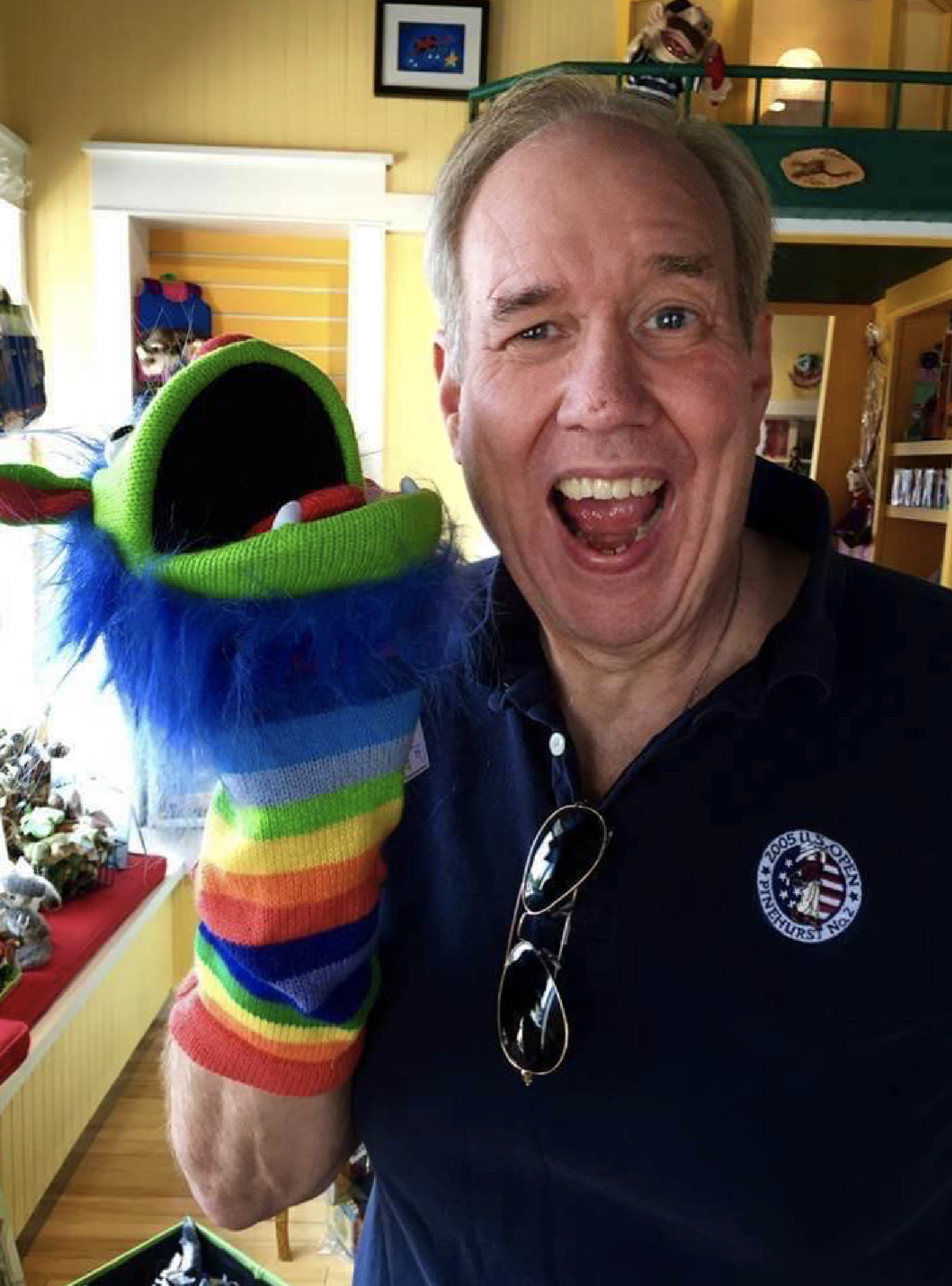 Bob Jones laughing with a colorful puppet